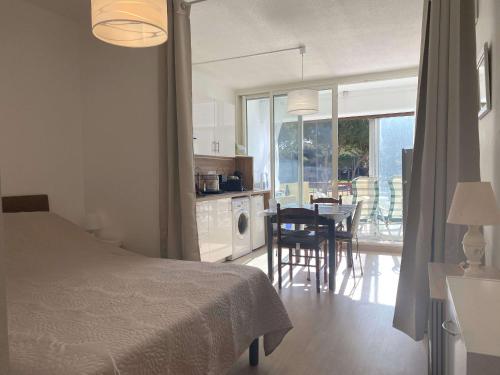 une chambre avec un lit et une cuisine avec une table dans l'établissement Charmant T1 rénové avec terrasse, climatisation et WiFi à Balaruc-les-Bains - FR-1-553-282, à Balaruc-les-Bains