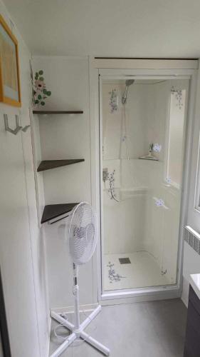 une douche blanche avec un ventilateur dans une salle de bain dans l'établissement Mobil home Piriac détente boisée, à Piriac-sur-Mer