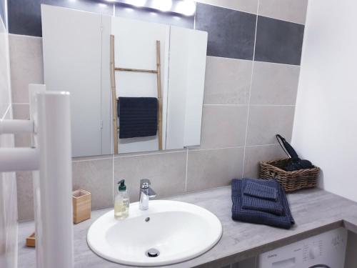 une salle de bain avec un lavabo blanc et un miroir dans l'établissement Le Tilleul By Tranquil at Home, à La Baule