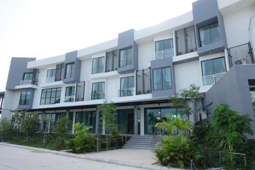 an apartment building with a staircase in front of it at Hotel Chuan Chom The High Resort Saraburi - SHA Plus in Sara Buri