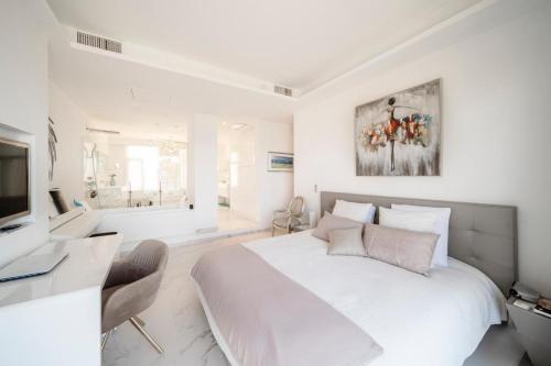 - une chambre blanche avec un grand lit et une salle de bains dans l'établissement Stunning 3 bedrooms with a sea view terrace, à Cannes