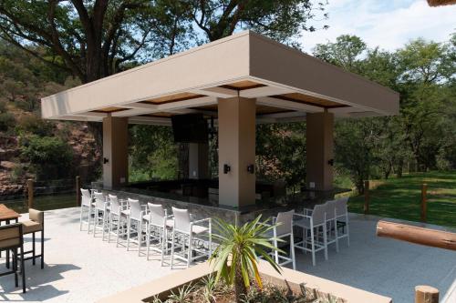 a pavilion with chairs and a bar at Mologa River Lodge in Rust de Winter
