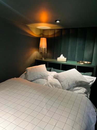 a large white bed in a room with a lamp at Piotrkowska 37 -MINI LOFT- Green Leaf in Łódź
