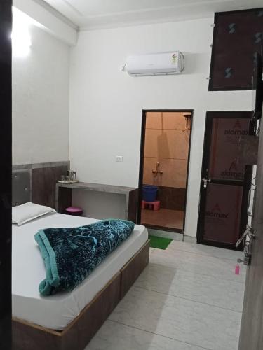 a bedroom with a bed and a bathroom with a mirror at Hotel Raj krishnam khatushyamji in Khātu