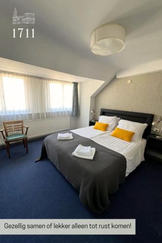 ein Schlafzimmer mit einem großen Bett, auf dem Handtücher liegen in der Unterkunft Hotel 1711 in Valkenburg