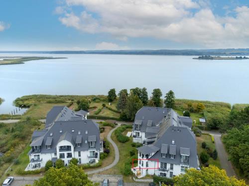 eine Luftaufnahme eines Hauses neben einem See in der Unterkunft Residenz am Balmer See - BS 22 mit Wellnessbereich in Balm