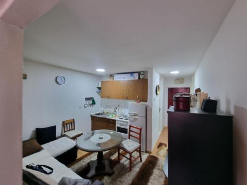 a kitchen and a living room with a couch and a table at Kenny in Zenica