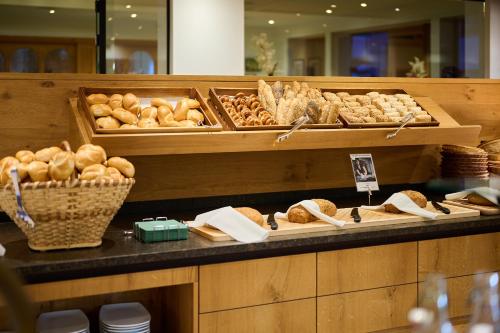 a bakery counter with various types of bread and pastries at Landhotel Schermer in Westendorf