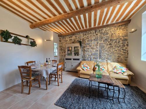 un salon avec une table et un canapé dans l'établissement Maison Le Levant à Chauzon, à Chauzon