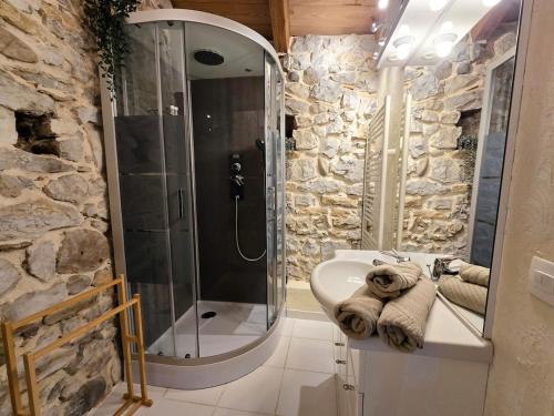 ein Badezimmer mit Dusche und Waschbecken mit Handtüchern in der Unterkunft Maison Le Levant à Chauzon in Chauzon