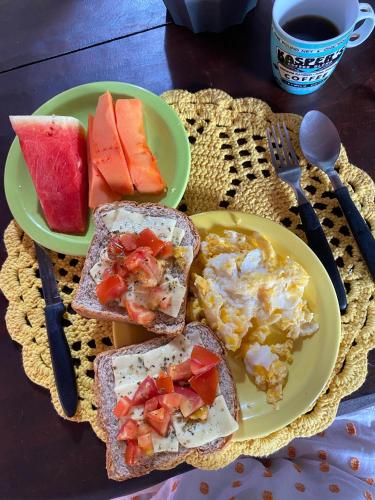 a plate of toast with eggs and fruit and a cup of coffee at Jardim dos Afetos in Jijoca de Jericoacoara