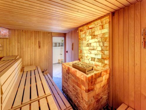 a sauna with a stone wall and benches in it at Residenz am Balmer See - BS 10 mit Wellnessbereich in Balm