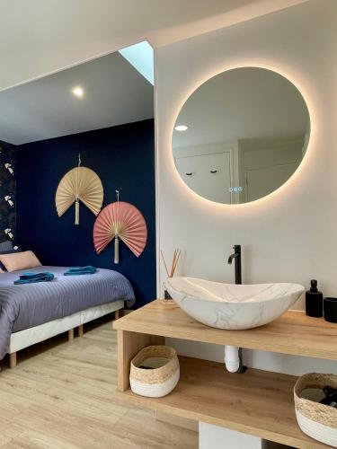 La salle de bains est pourvue d'un grand miroir et d'une baignoire. dans l'établissement Soleil levant - T2 avec terrasse proche Gare, à Amiens