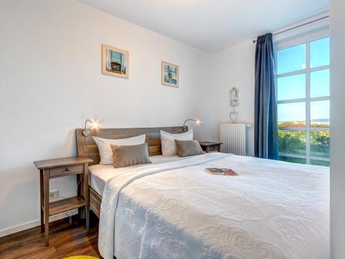 ein Schlafzimmer mit einem großen Bett mit einem großen Fenster in der Unterkunft Residenz am Balmer See - BS 38 mit Wellnessbereich in Balm