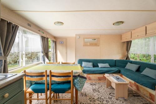 un salon avec un canapé et une table dans l'établissement Mobilhome Capacité 2 à 4 personnes, à Pluduno