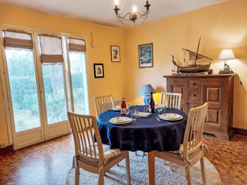une salle à manger avec une table et des chaises bleues dans l'établissement Holiday Home Monteno by Interhome, à Arzon