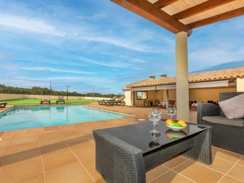 a patio with a table and chairs next to a swimming pool at Holiday Home Can Cals by Interhome in Fonteta