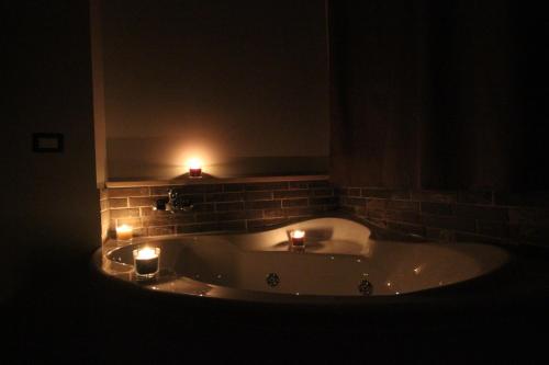 a bathroom with a bath tub with candles in it at Pianeta Roma 127 in Rome