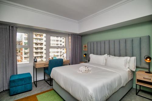 a bedroom with a bed and a desk and a window at 9 On Barrack in Cape Town