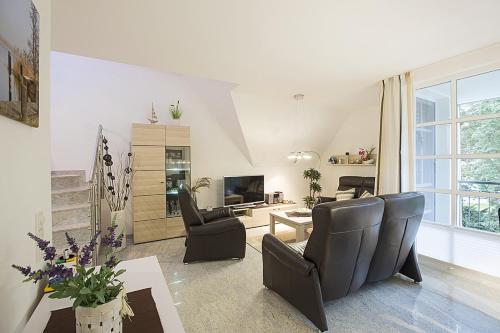a living room with two chairs and a television at Residenz am Balmer See - BS 31 mit Wellnessbereich in Balm