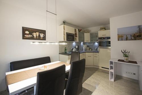 a kitchen with a table and chairs in a room at Residenz am Balmer See - BS 31 mit Wellnessbereich in Balm