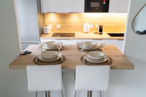 une cuisine avec une table avec des assiettes et des verres à vin dans l'établissement Féérie Parisienne, un séjour enchanté à Disneyland, à Montévrain