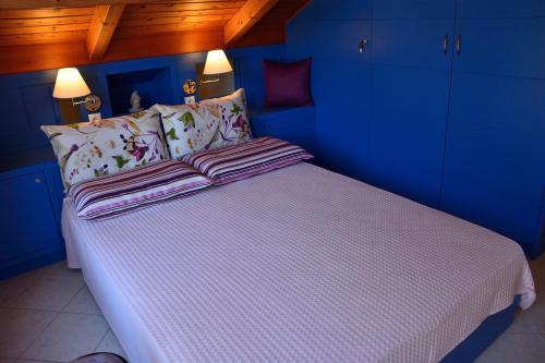 a blue bedroom with a large bed with white sheets at Kimataki in Frikes