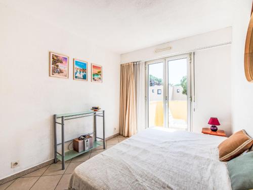 une chambre avec un lit et une grande fenêtre dans l'établissement Apartment Le Palazzo del Mar-9 by Interhome, à Cavalaire-sur-Mer