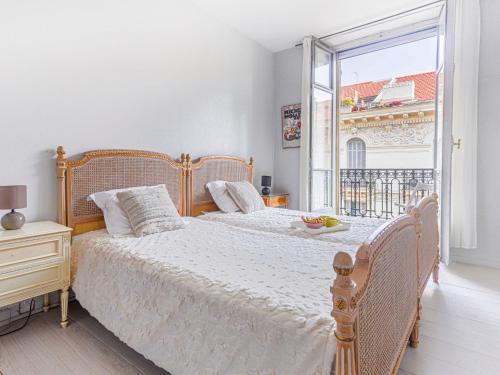 une chambre avec deux lits et une grande fenêtre dans l'établissement Apartment Le Concordia by Interhome, à Nice