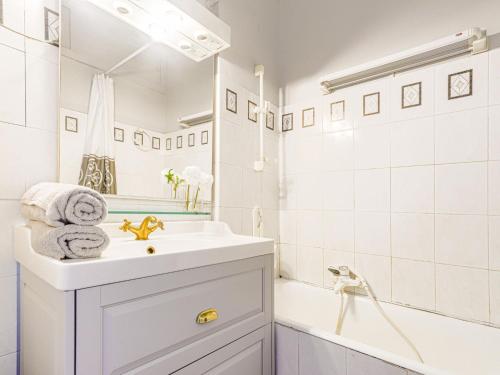 La salle de bains blanche est pourvue d'un lavabo et d'une baignoire. dans l'établissement Apartment Le Concordia by Interhome, à Nice