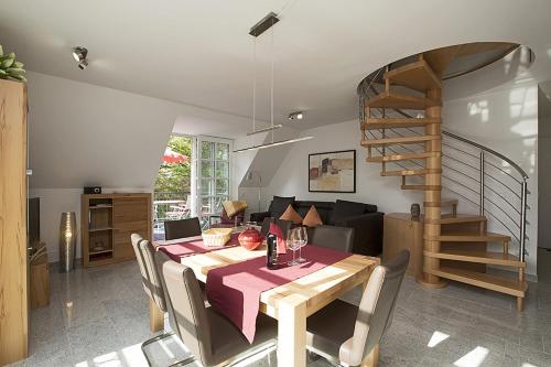 a dining room with a table and a spiral staircase at Residenz am Balmer See - BS 32 mit Wellnessbereich in Balm