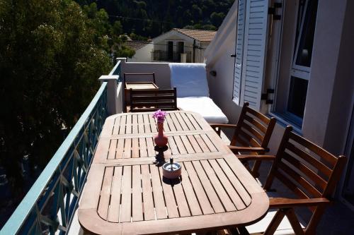 a wooden table and chairs on a balcony at Kimataki in Frikes