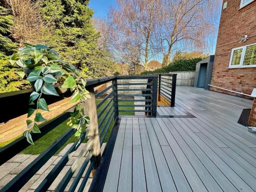 a wooden deck with a fence and a plant at Eden Escape - Bham Airport, NEC, HS2, JLR, Park Access in Sheldon