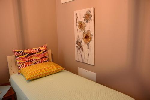 a bed with a pillow and a painting on the wall at Kimataki in Frikes