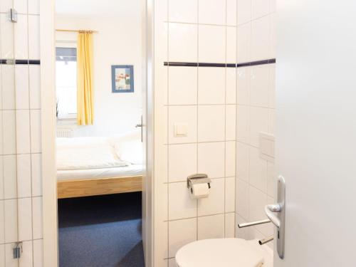 a bathroom with a toilet and a bed in a room at Apartment Jeschek by Interhome in Ostseebad Koserow