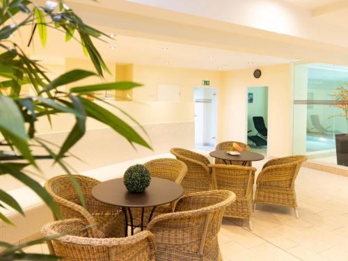 two tables and wicker chairs in a room at Apartment Südwind App- 9 by Interhome in Zempin