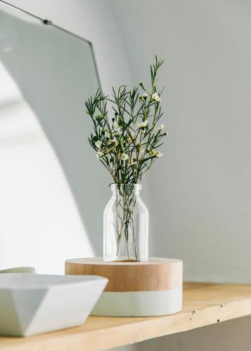 a vase with flowers on a wooden shelf at Guest House Ibaia Et Arramak in Donostia-San Sebastián