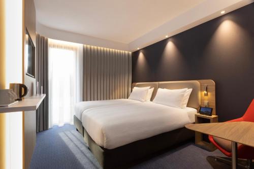 a hotel room with a white bed and a desk at Holiday Inn Express & Suites - Deventer by IHG in Deventer