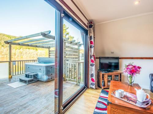 a living room with a large sliding glass door at Chalet Lodge 26 by Interhome in Spean Bridge