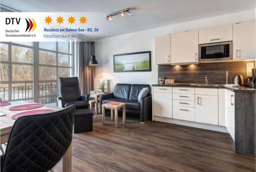 a kitchen and living room with a table and chairs at Residenz am Balmer See - BS 56 mit Wellnessbereich in Balm