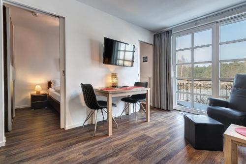 a living room with a desk and a bedroom at Residenz am Balmer See - BS 56 mit Wellnessbereich in Balm