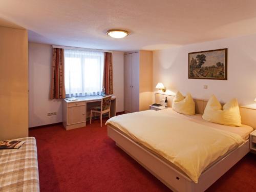 una camera d'albergo con letto e scrivania di Haus Odo a Lech am Arlberg