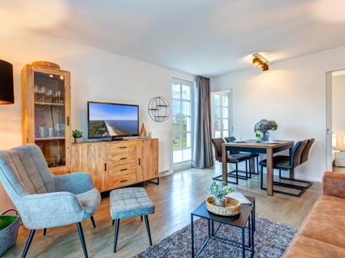 a living room with a tv and a table at Residenz am Balmer See - BS 43 mit Wellnessbereich in Balm