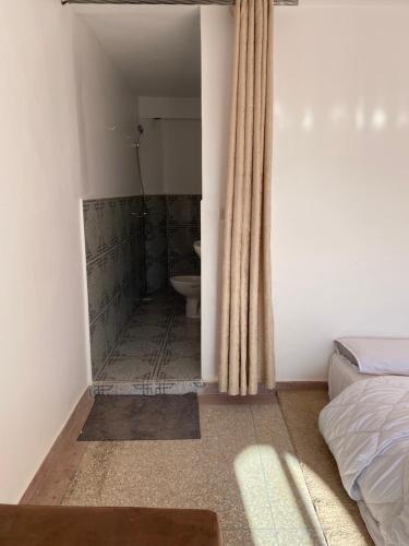 a bedroom with a bathroom with a toilet in it at room in tamraght - 10min walk to the beach in Aourir