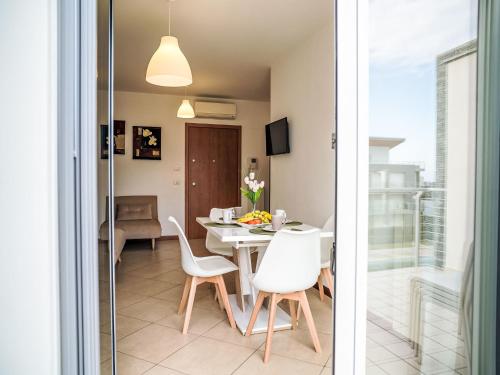 a dining room with a table and white chairs at Apartment Le Dune by Interhome in Silvi Marina