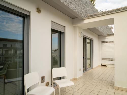 a patio with white chairs and a roof at Apartment Le Dune by Interhome in Silvi Marina