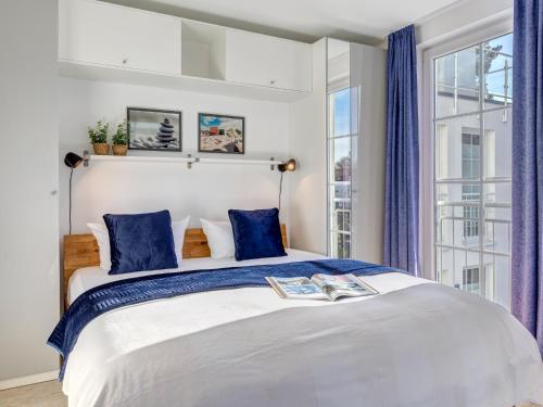 a bedroom with a large white bed with blue pillows at Ostseeresidenz Gorki- Park - 16 mit Wellness und Schwimmbad in Bansin
