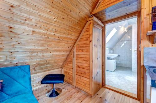 a log cabin with a blue chair in a room with a window at Ferienhaus Renate Dachgeschosswohnung 4 in Bansin