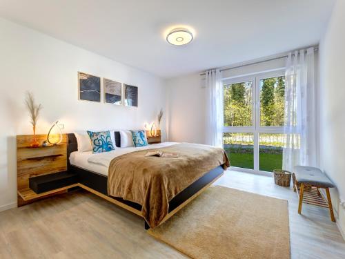 a bedroom with a bed and a large window at Bernsteinquartier BQ 0548 in Kolpinsee