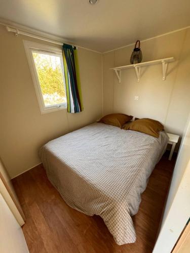 une petite chambre avec un lit et une fenêtre dans l'établissement Bungalow Balnéo Jacuzzi Sauna, à Erquy
